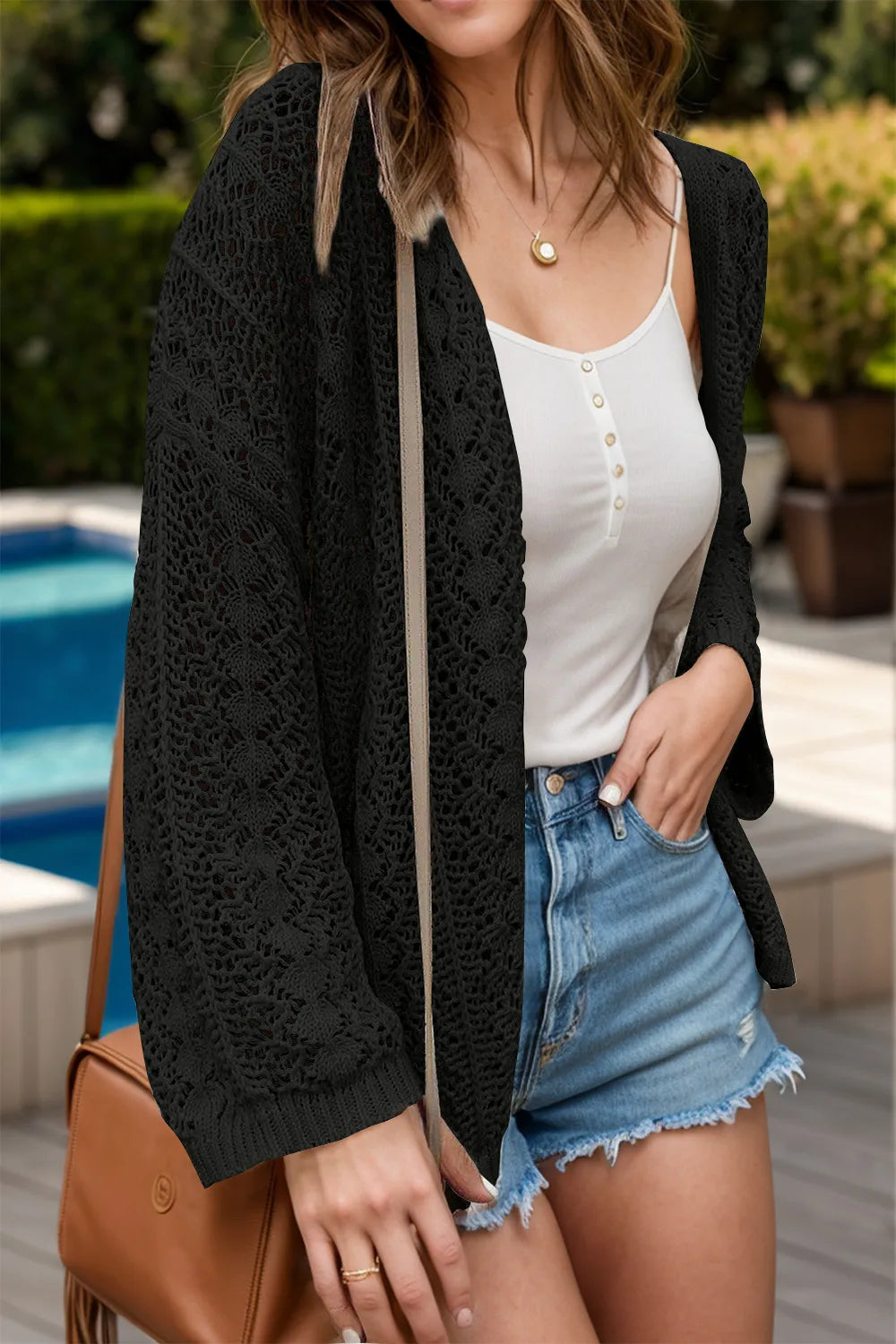 Openwork Open Front Dropped Shoulder Cardigan worn over a white tank top, paired with denim shorts, by a pool.